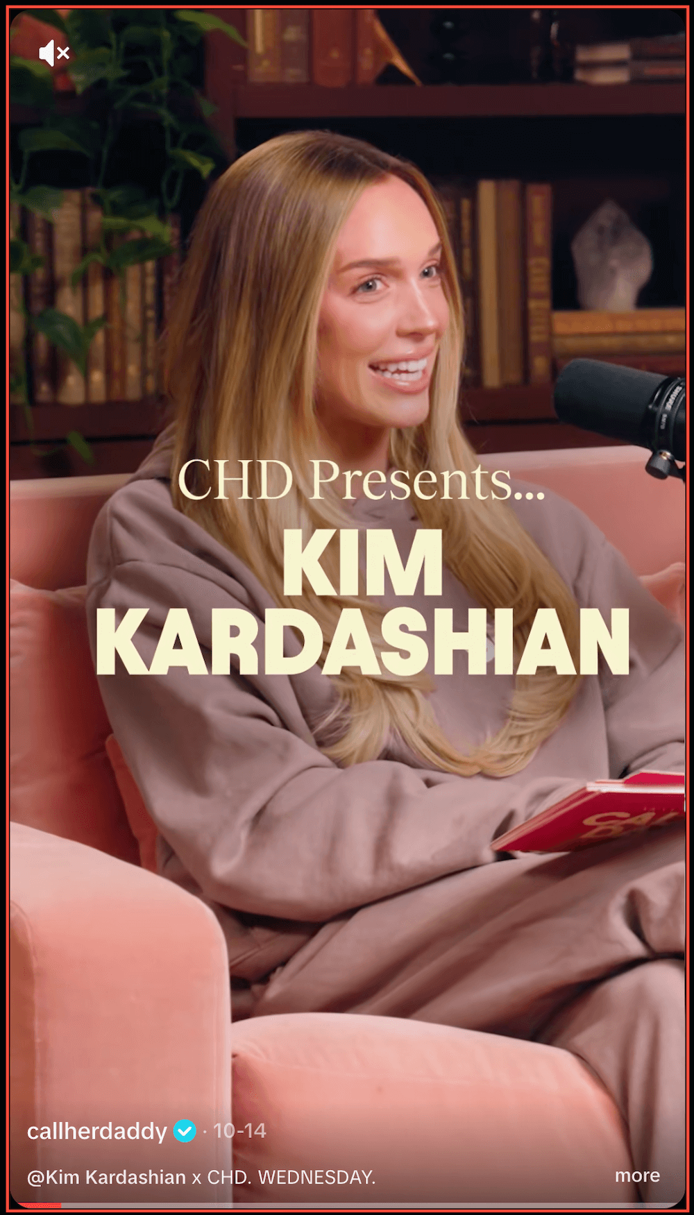 Screenshot of a TikTok video featuring Alex Cooper sitting in a chair in a library setting with text on the screen introducing Kim Kardashian.