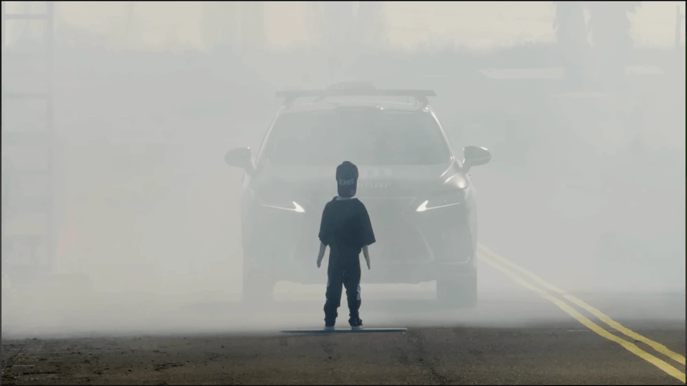 Screenshot of a YouTube video depicting a car stopping short of running over a mannequin surrounded by a cloud of mist.