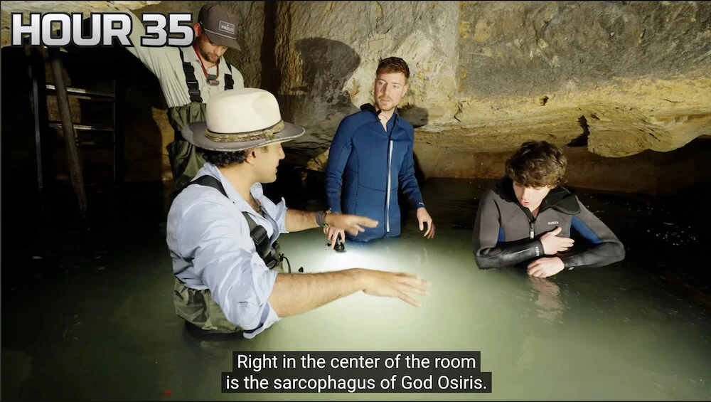 Screenshot of a YouTube video with MrBeast and several other people on screen standing in a pool of water in a cave.